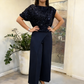 Ensemble élégant composé d'un haut à paillettes et d'un pantalon fendu à l'avant